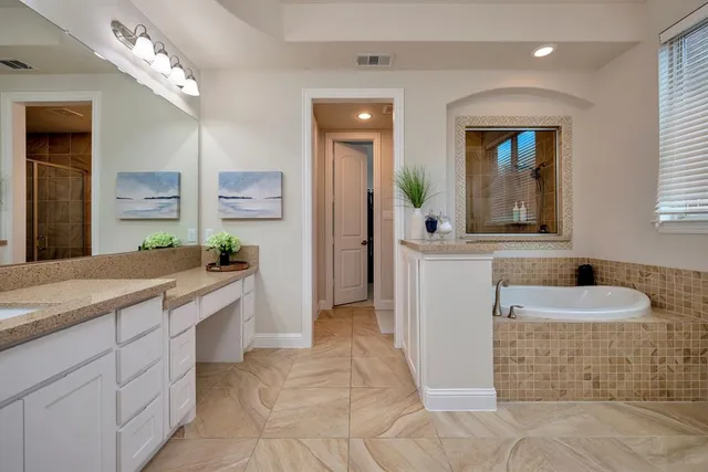 a spacious bathroom with a granite countertop sink and a mirror