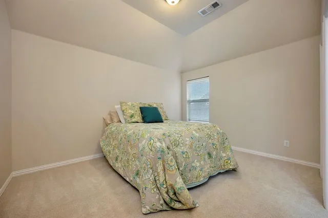 a bed sitting in a bedroom next to a window