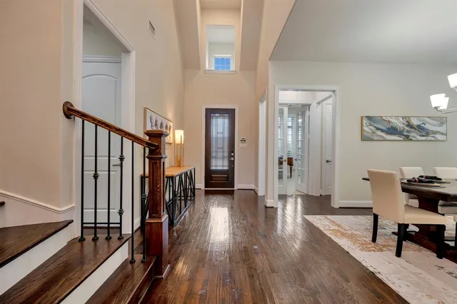 a hallway with wooden floor table and chairs