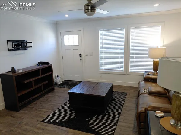 a view of a hallway with wooden floor and a cabinet