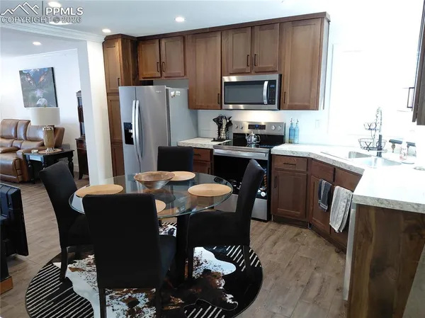 a kitchen with stainless steel appliances granite countertop a refrigerator a sink a stove a microwave and wooden cabinets