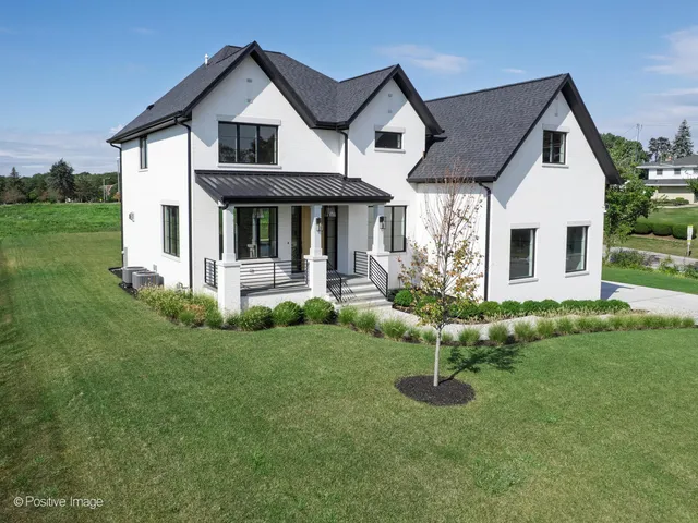a view of a house with a yard and potted plants