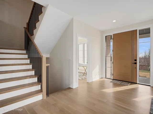 a view of a livingroom with wooden floor and stairs