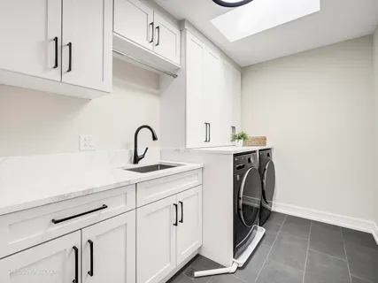 a utility room with sink dryer and washer
