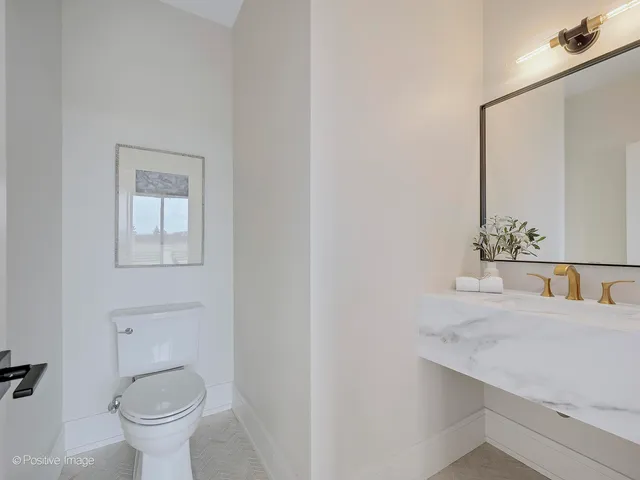 a bathroom with a toilet a sink and mirror