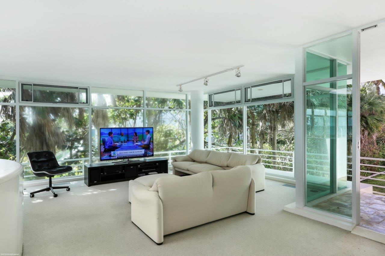 35 North Beach Road Hobe Sound, FL 33455 - Photo 26 of 44 a living room with furniture a flat screen tv and a floor to ceiling window