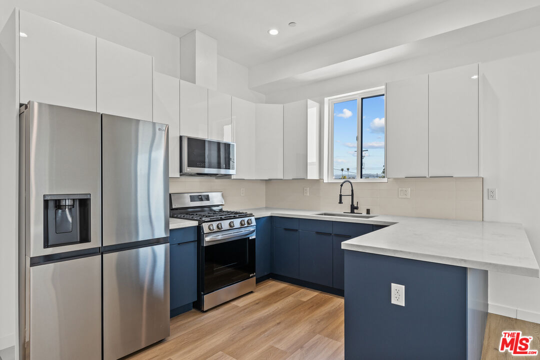 2923 South Burnside Avenue Los Angeles, CA 90016 - Photo 5 of 26 a kitchen with a refrigerator sink and stove
