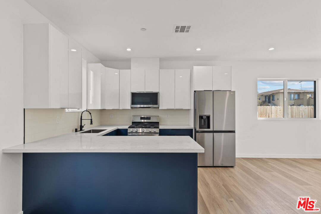 2923 South Burnside Avenue Los Angeles, CA 90016 - Photo 6 of 26 a kitchen with stainless steel appliances a refrigerator and a stove top oven