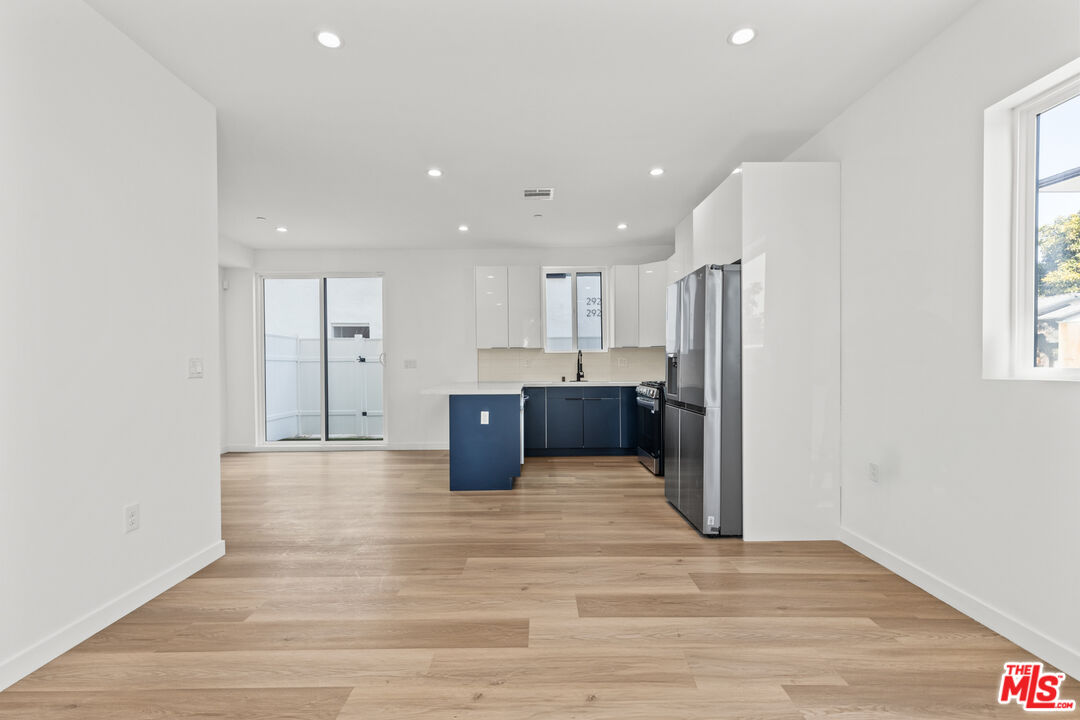 2923 South Burnside Avenue Los Angeles, CA 90016 - Photo 7 of 26 a view of kitchen with refrigerator microwave and wooden floor