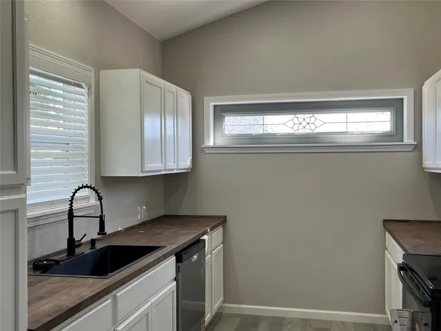 a kitchen with stainless steel appliances granite countertop white cabinets stove top oven and microwave