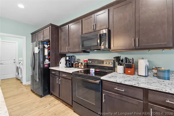 a kitchen with stainless steel appliances granite countertop a refrigerator stove and sink
