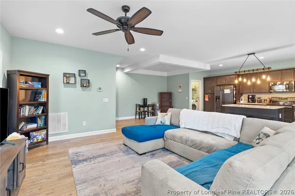 a living room with furniture and a ceiling fan
