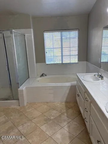 a bathroom with a granite countertop bathtub sink and mirror