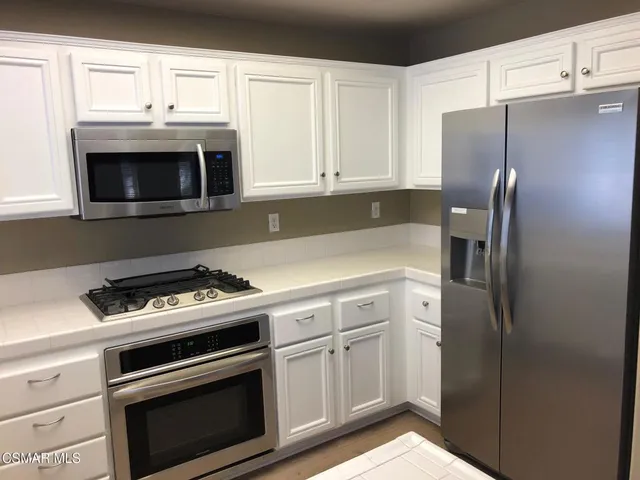 a kitchen with cabinets and stainless steel appliances