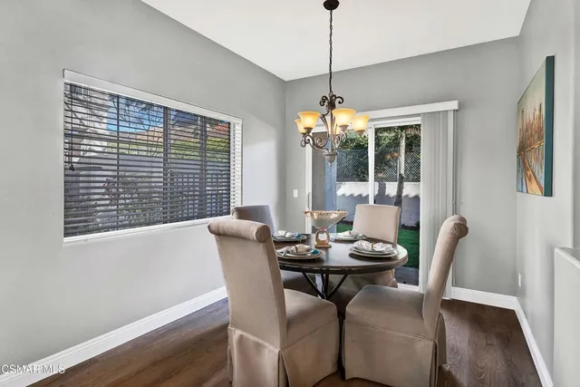 a dining room with furniture a chandelier and wooden floor