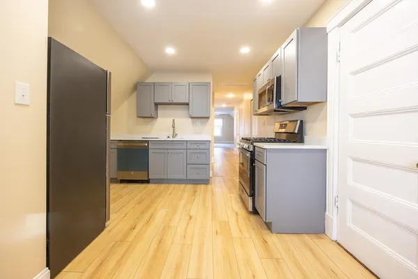 a kitchen with stainless steel appliances granite countertop a sink stove and refrigerator