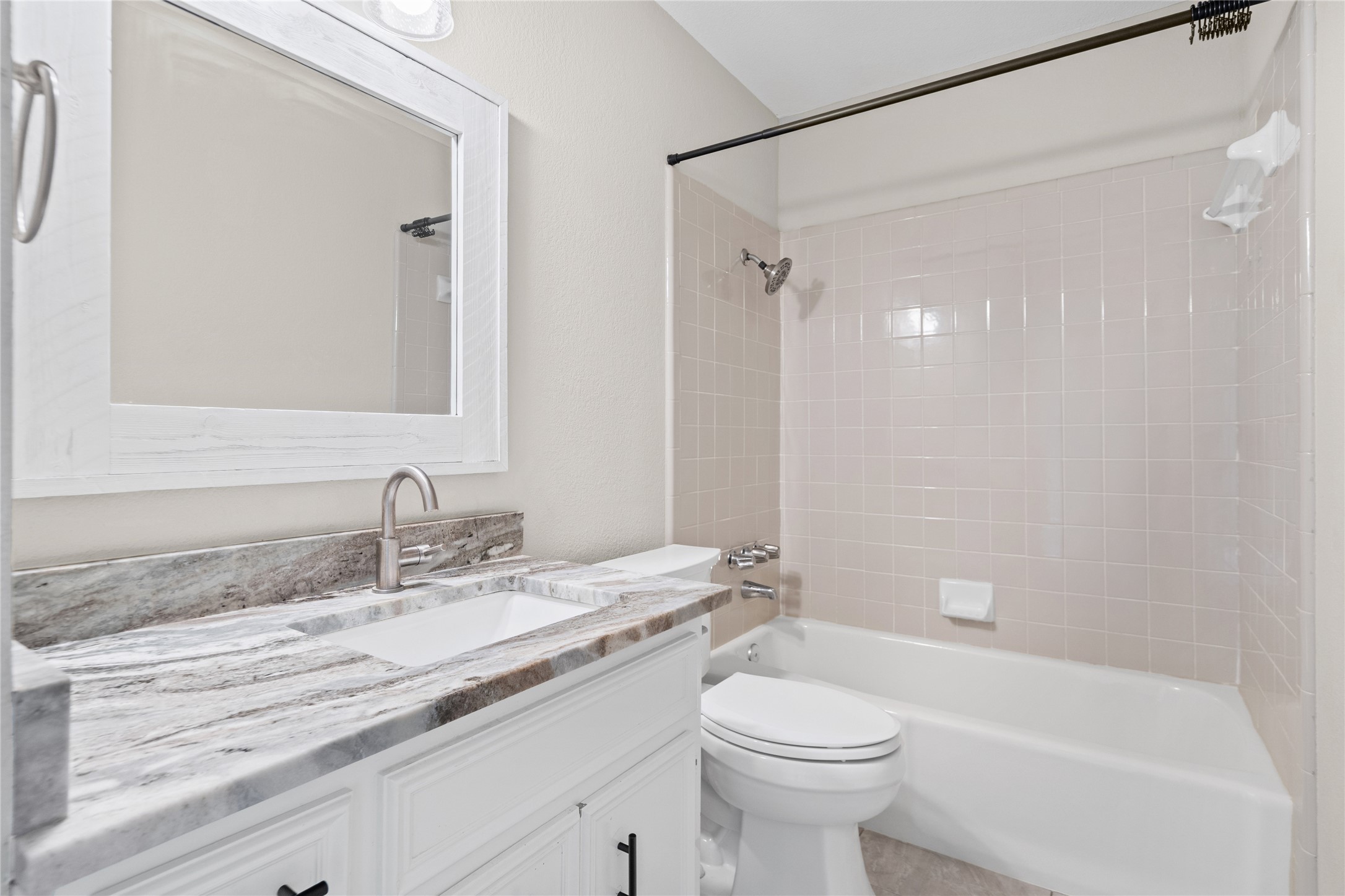 810 Stillhouse Spring Round Rock, TX 78681 - Photo 14 of 18 A well-appointed bathroom features a sleek vanity with a striking granite countertop and a practical shower-tub combination.