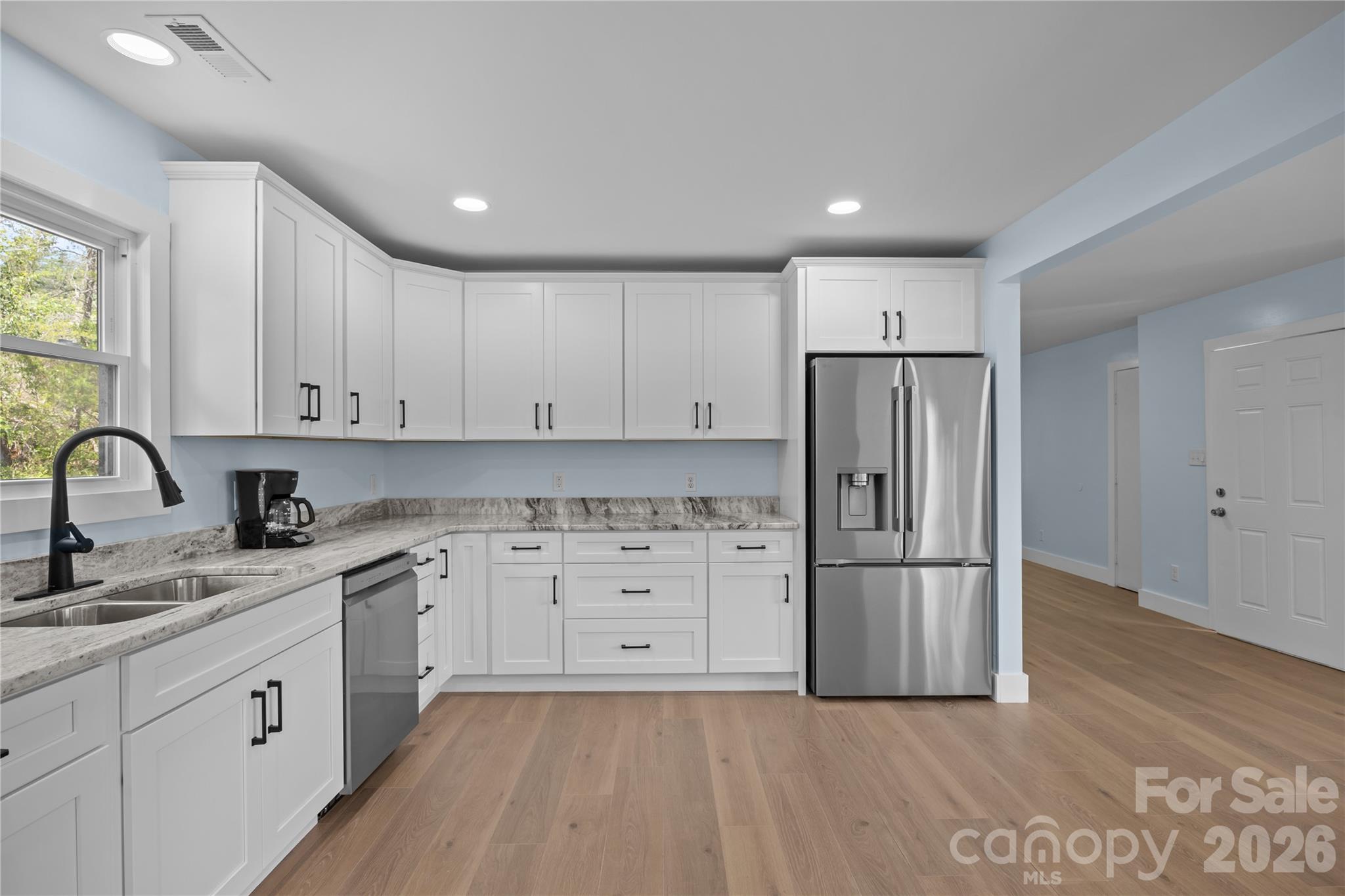221 John C Logan Road Rutherfordton, NC 28139 - Photo 3 of 20 a kitchen with white cabinets white stainless steel appliances and sink