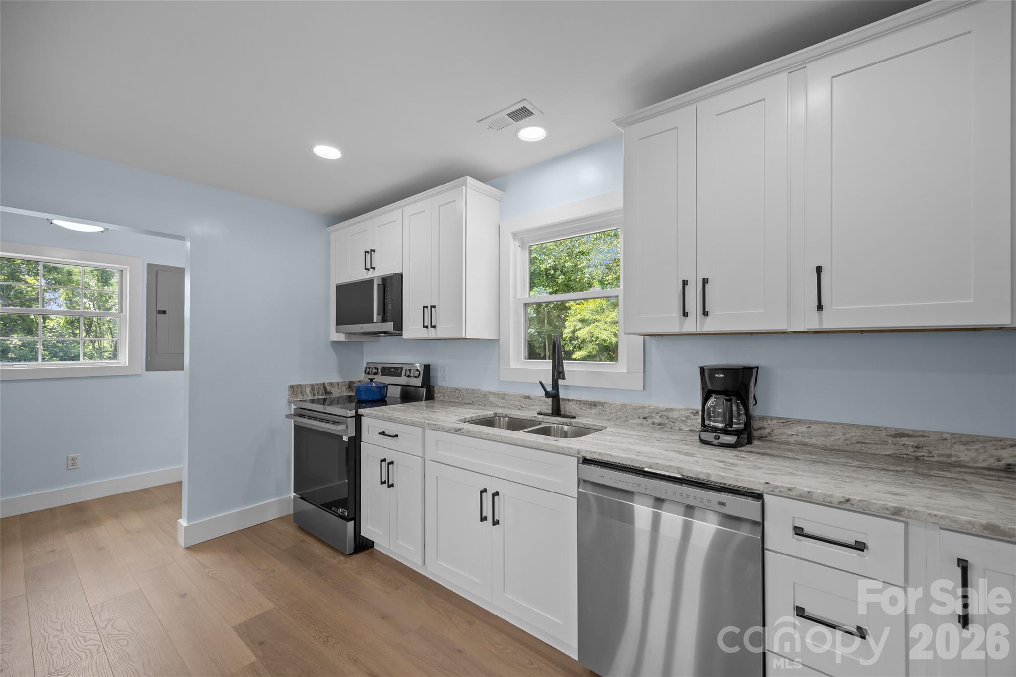 221 John C Logan Road Rutherfordton, NC 28139 - Photo 4 of 20 a kitchen with granite countertop a sink a stove a microwave and wooden cabinets