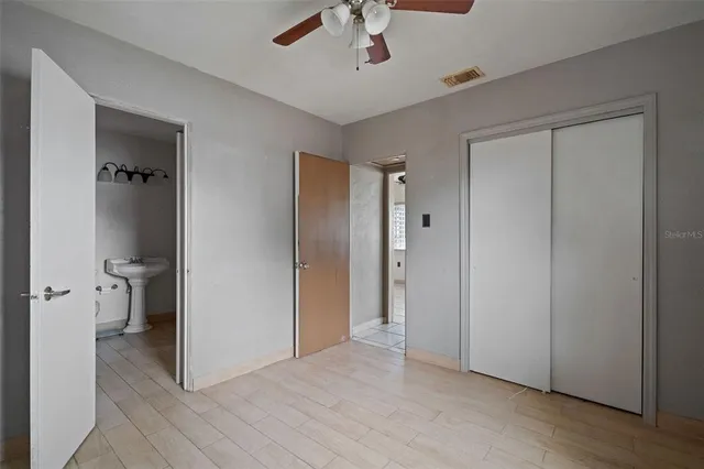 a view of a room with a stylish ceiling fan and entryway