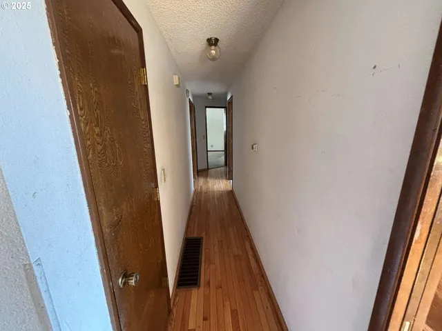 an empty room with windows tv and wooden floor