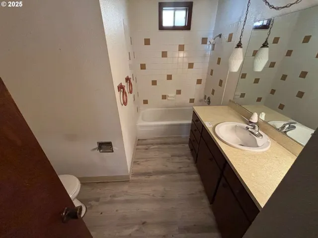 a bathroom with a sink double vanity granite tub shower and mirror