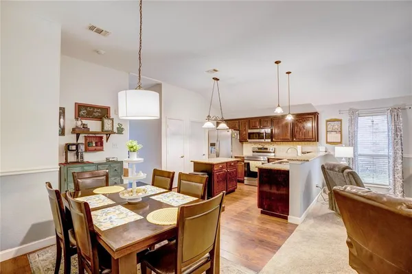 a view of a dining room and livingroom furniture wooden floor a rug and a chandelier