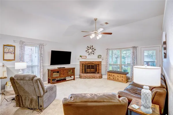 a living room with furniture a fireplace and a flat screen tv