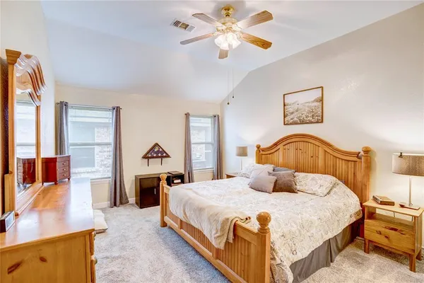 a bedroom with a bed and dresser with mirror