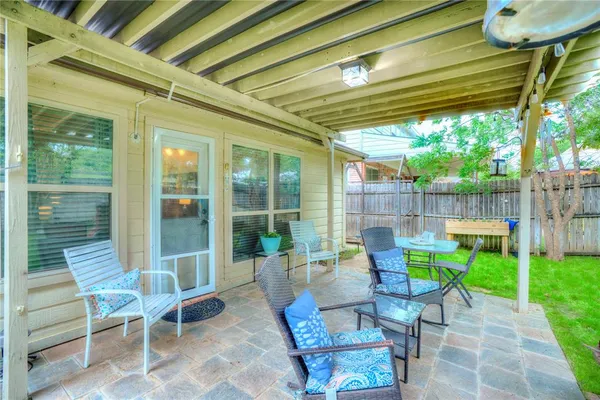 a view of a patio with a table and chairs and potted plants
