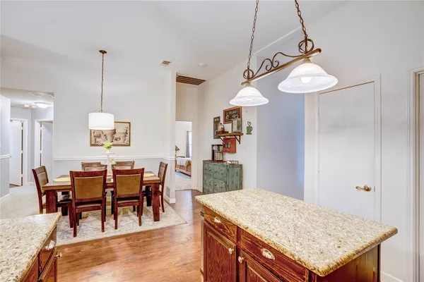 a view of a dining room and livingroom furniture wooden floor a rug and a chandelier