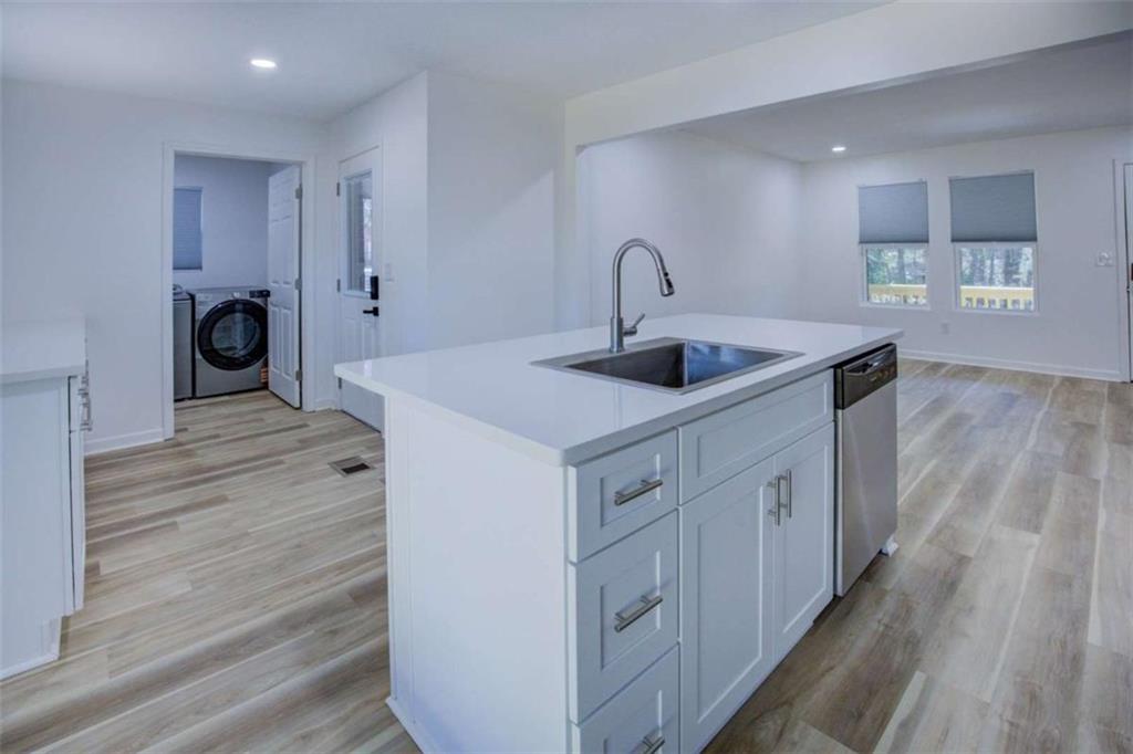 7225 Pineneedle Drive Southwest Covington, GA 30014 - Photo 11 of 37 a kitchen with sink a refrigerator and wooden floor