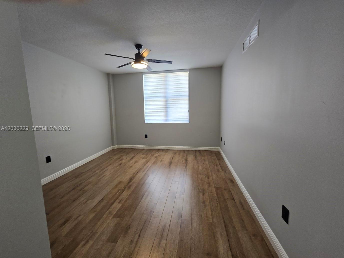 888 Douglas Road, Unit 605 Coral Gables, FL 33134 - Photo 12 of 21 wooden floor in an empty room with a window