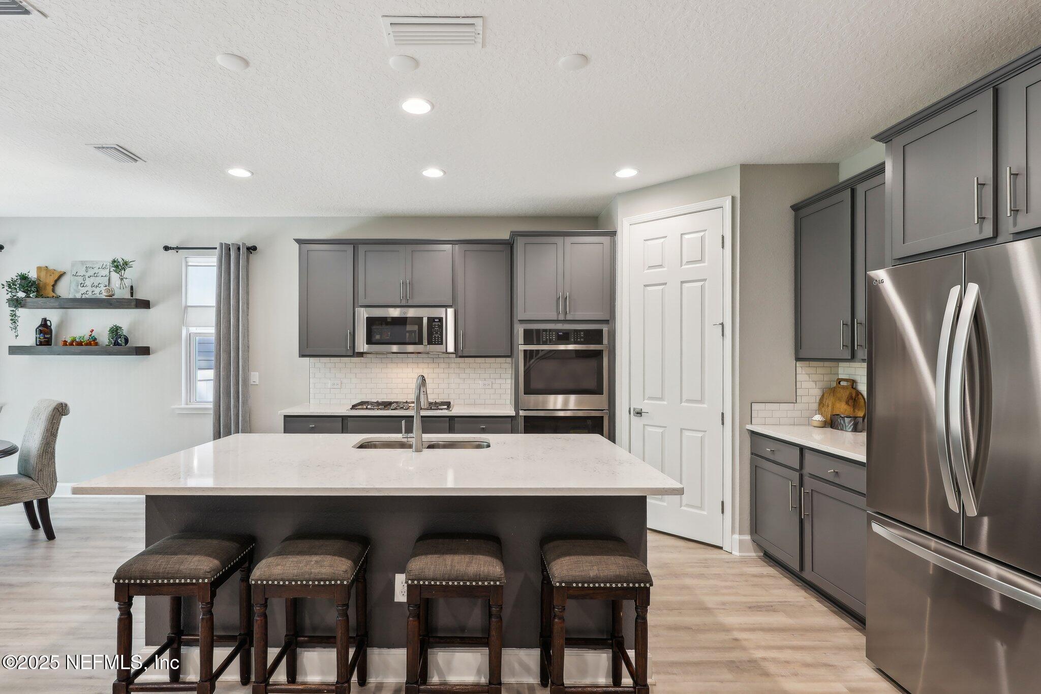 138 Wards Ravine Way St. Johns, FL 32259 - Photo 10 of 38 a kitchen with refrigerator cabinets dining table and chairs