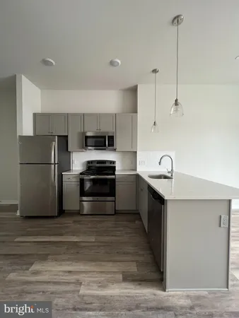a kitchen with kitchen island a sink stainless steel appliances and cabinets