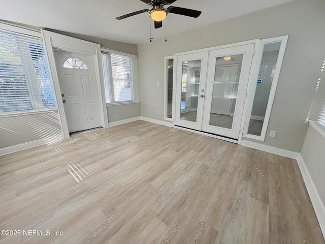 an empty room with wooden floor and windows