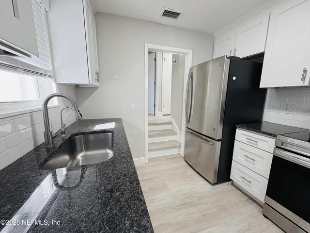 a kitchen with a refrigerator and a sink
