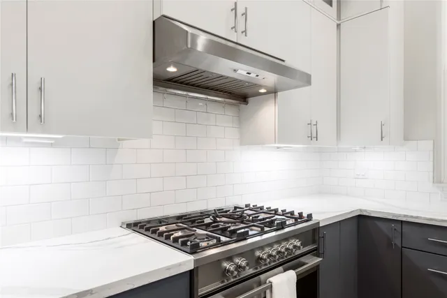 a work room with furniture a large window and wooden floor
