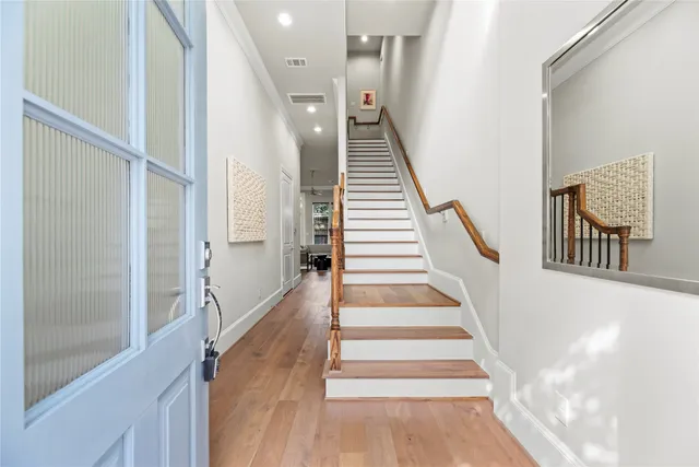a view of staircase with lots of frames on wall and wooden floor