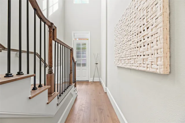 a view of a hallway with wooden floor and staircase