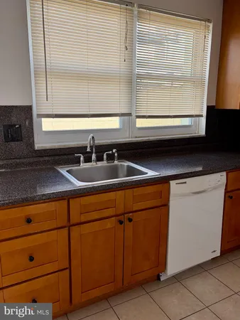 a kitchen with stainless steel appliances granite countertop a sink and a large window