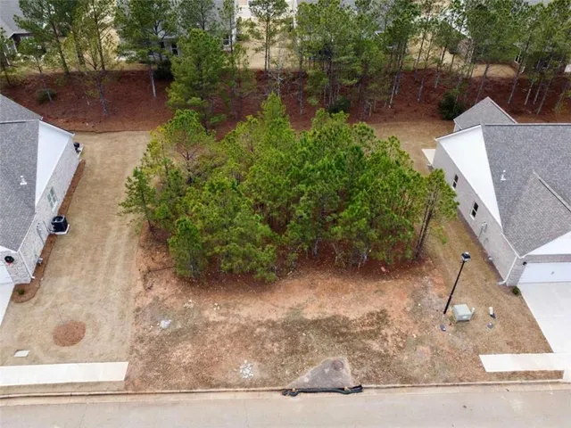 front view of house with a yard and trees all around