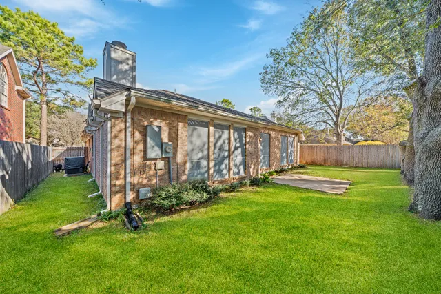 a view of a house with backyard and a tree