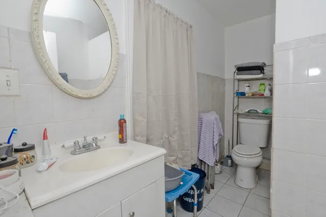 a bathroom with a sink vanity mirror and toilet