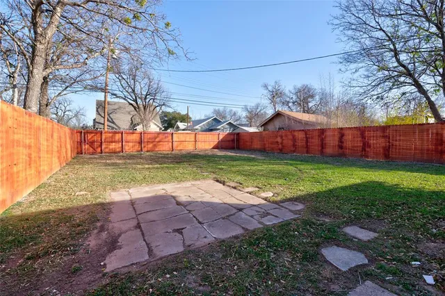a view of a yard with a house and a large tree