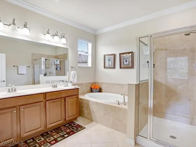 a bathroom with a double vanity sink mirror and bathtub