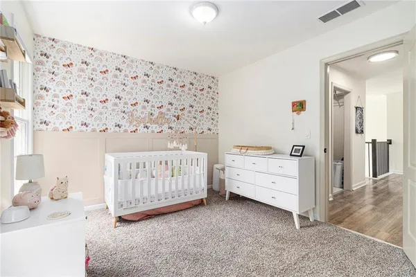 a room with a baby bed baby crib and a dresser