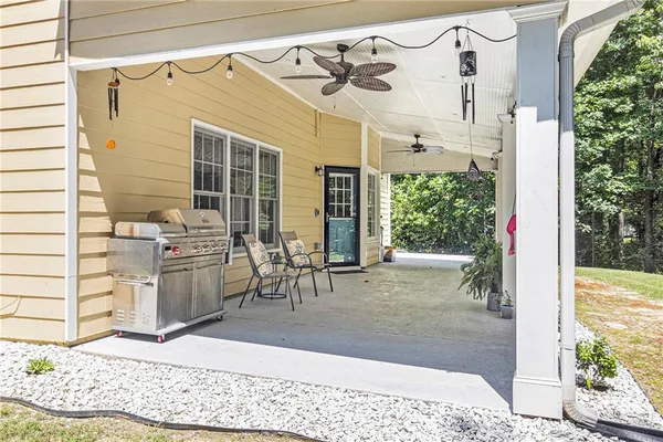 a view of a porch with chairs and potted plants
