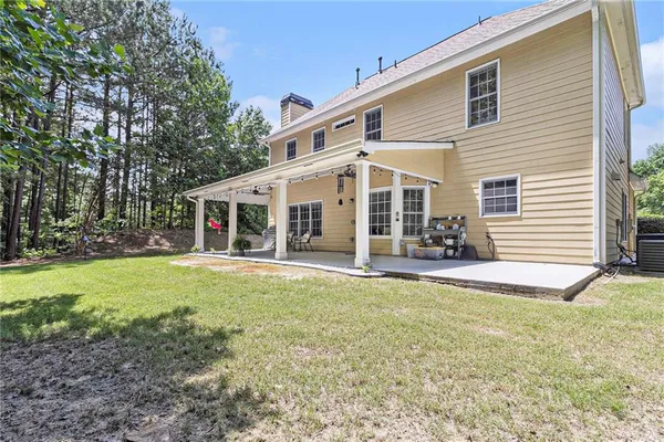 a view of a house with backyard porch and a small yard