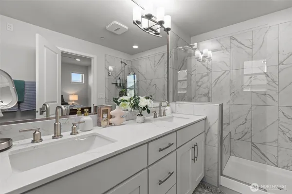a bathroom with a double vanity sink mirror and shower